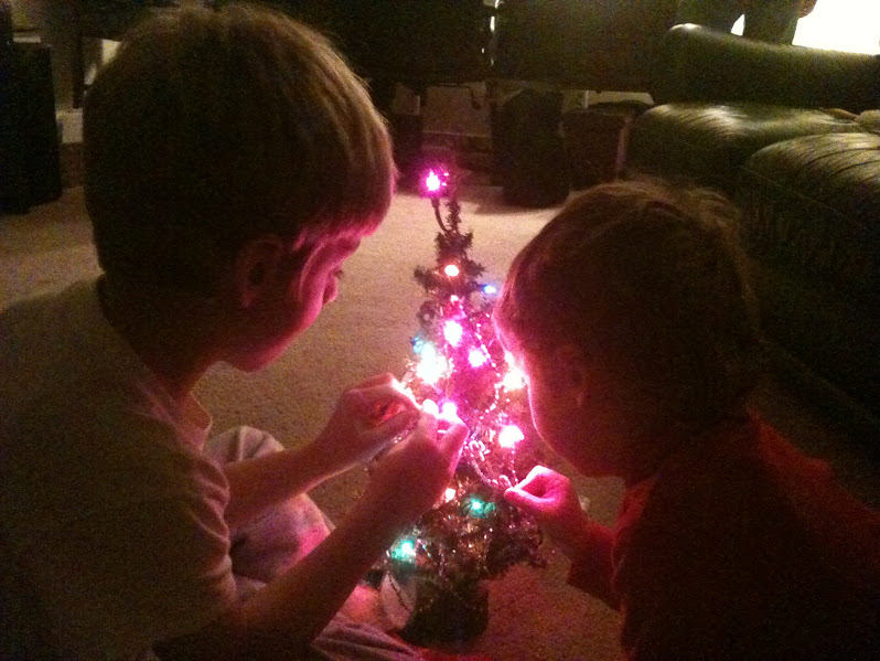 two boys decorating small Christmas tree