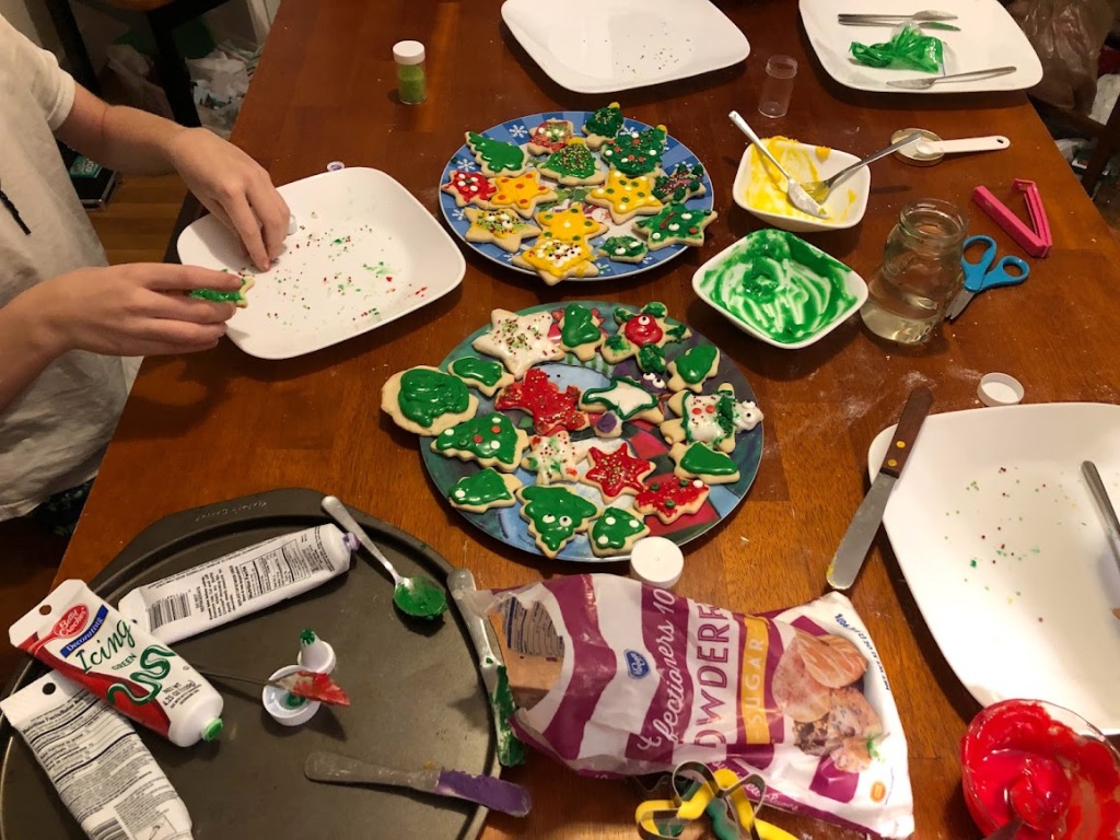 people decorating Christmas cookies at the kitchen table
